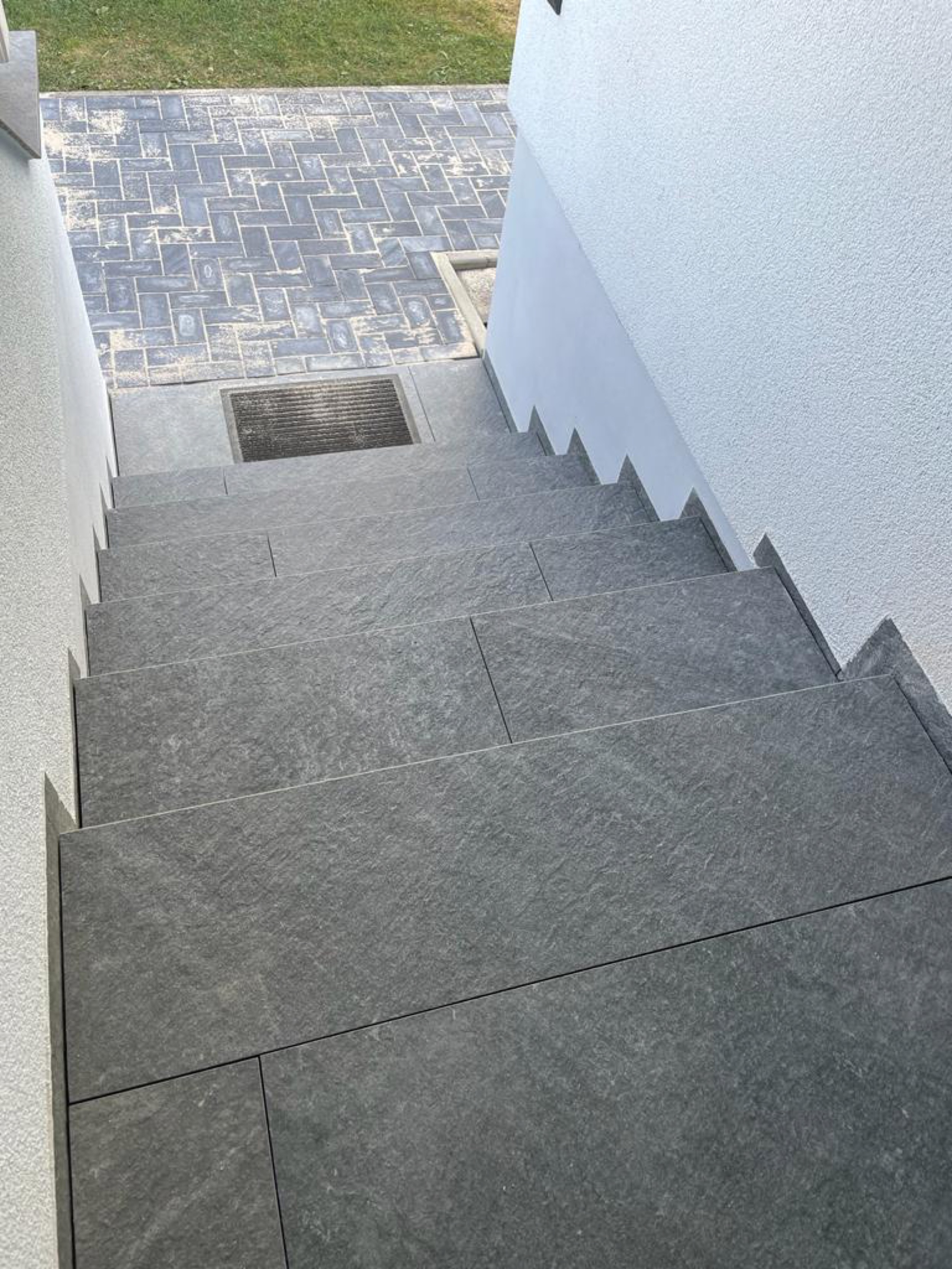 Außentreppe aus Naturstein mit Blick auf den gepflasterten Hof