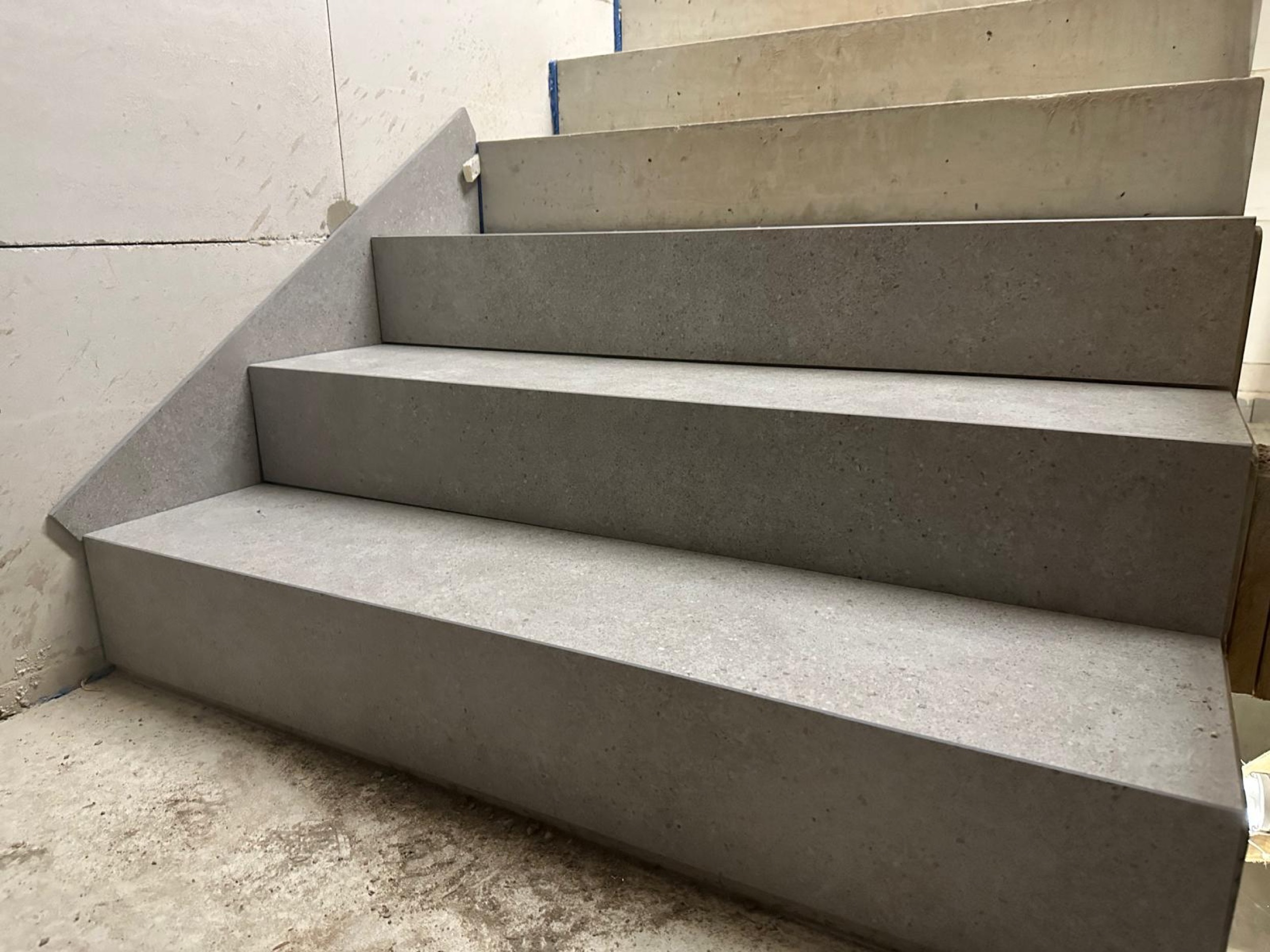 Eckdetail einer grauen Natursteintreppe im Rohbau