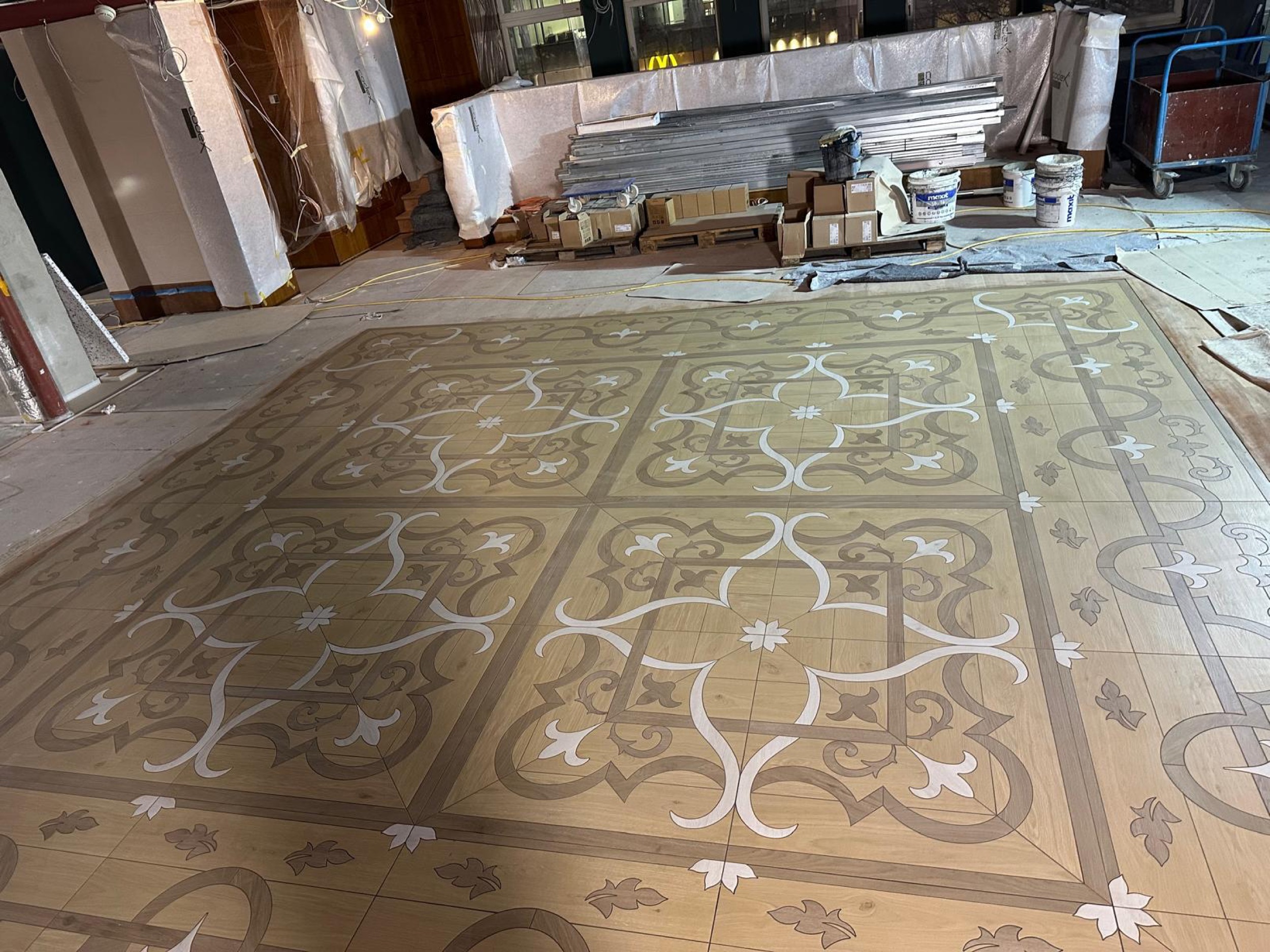 camt ornamentboden in holzoptik schraege nahansicht mit verpackten materialien und eimern im hintergrund