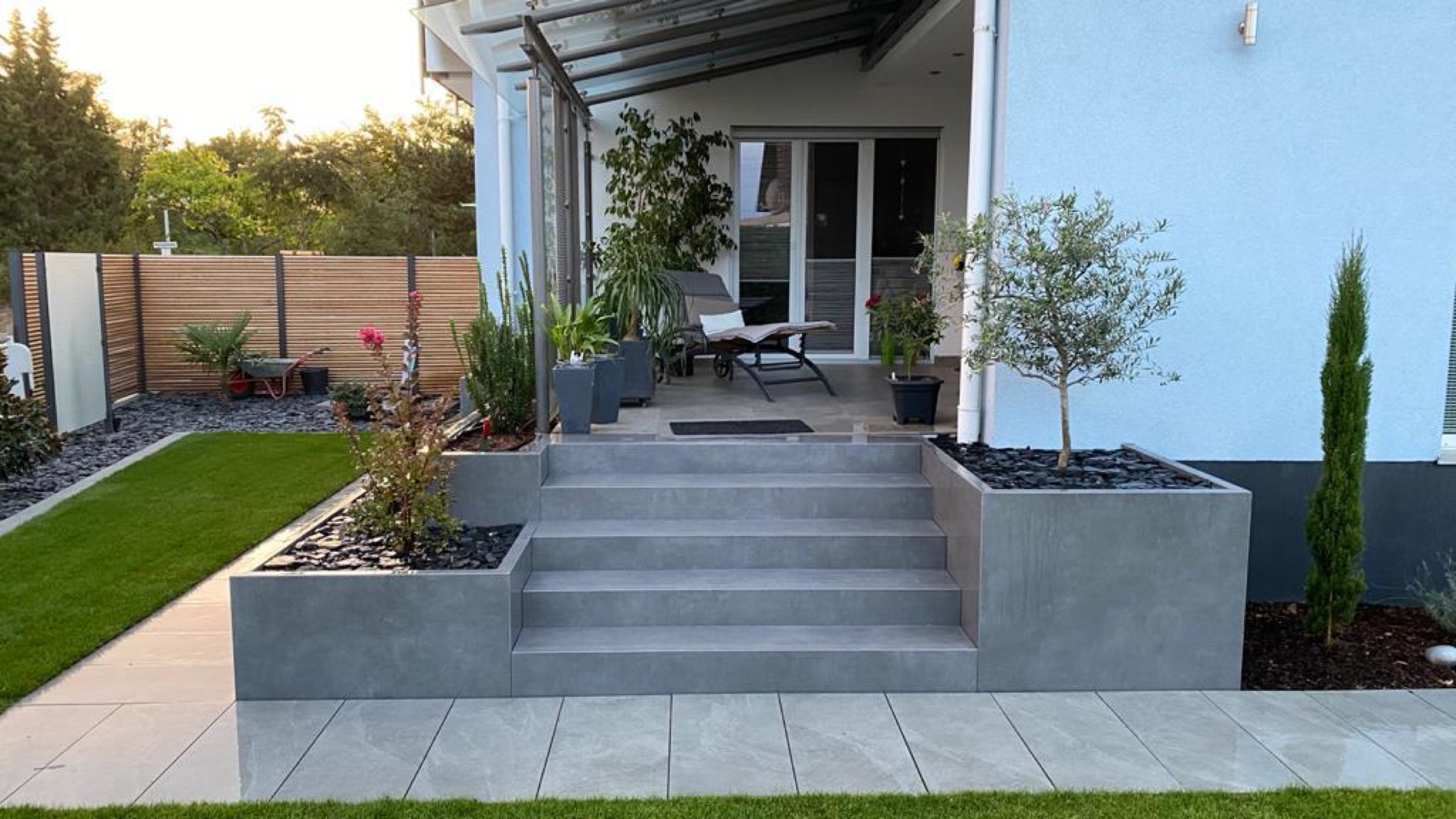 Terrassentreppe aus grauem Naturstein mit integrierten Pflanzkübeln