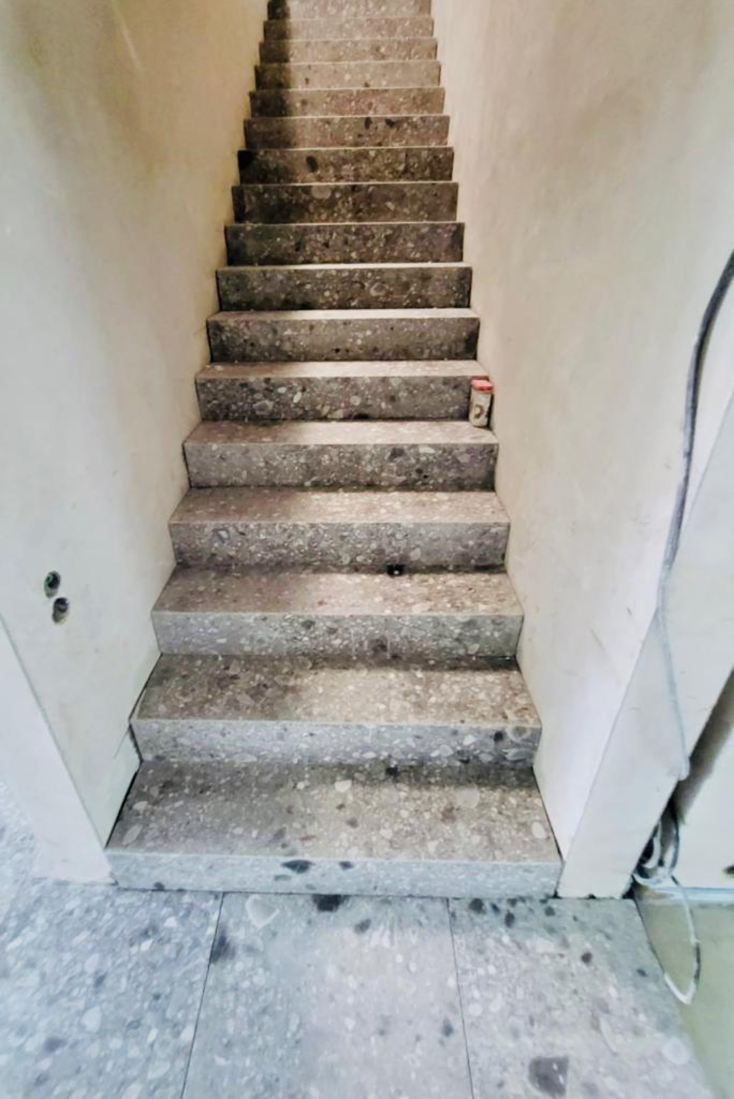 Terrazzotreppe in einem Wohnhaus mit weißen Wänden