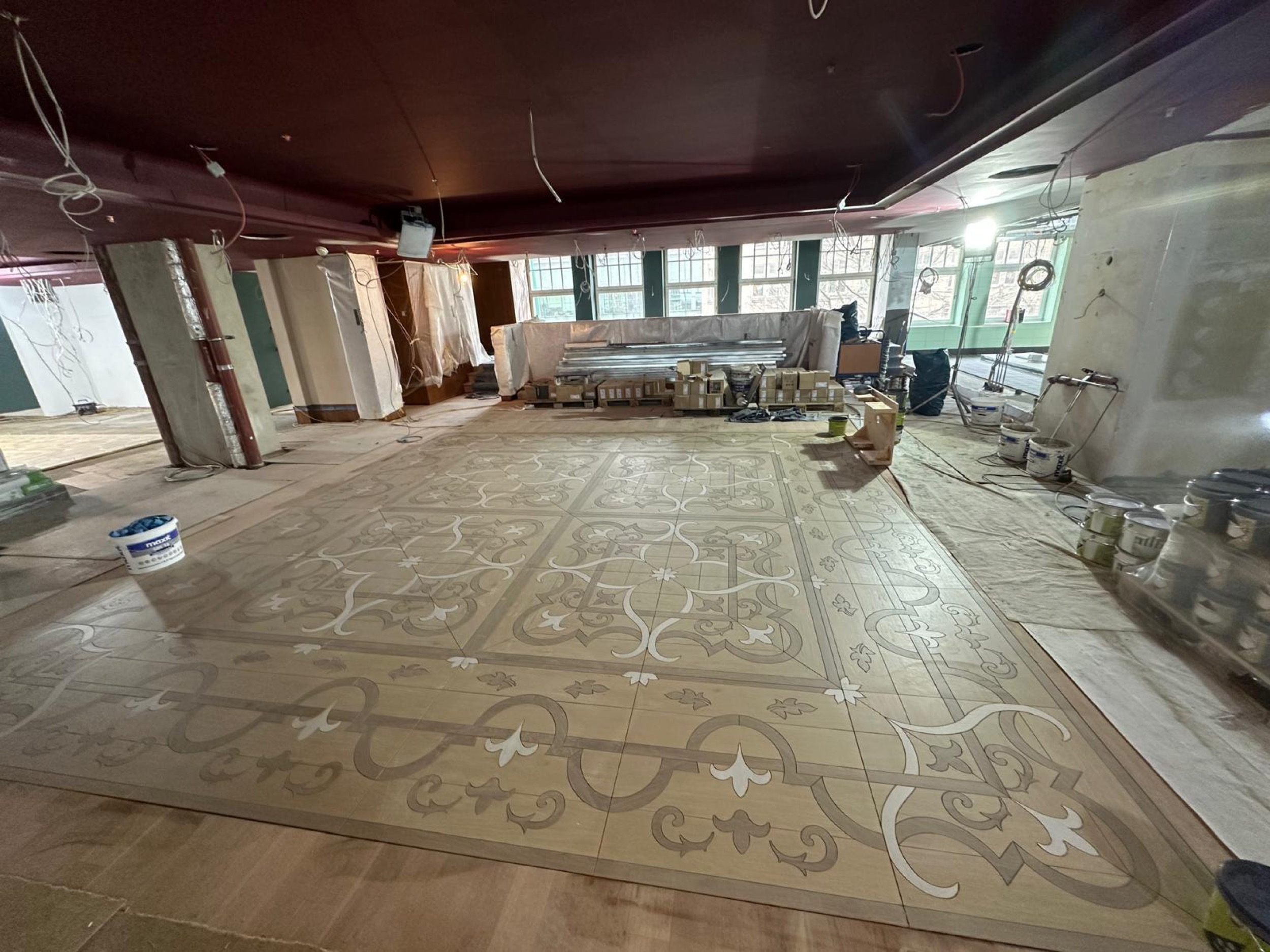 Verlegter Ornamentboden in Holzoptik mit Lilienmotiven und Ranken auf der Baustelle